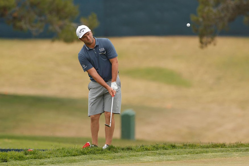 Jon Rahm plays a chip.