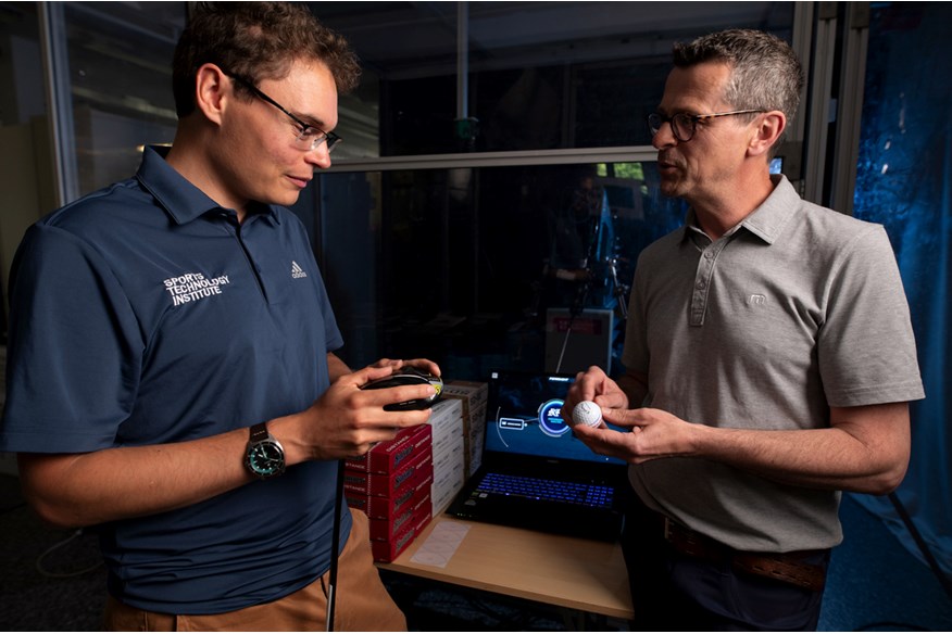 PhD Associate James Morris discussing golf balls with Simon Daddow